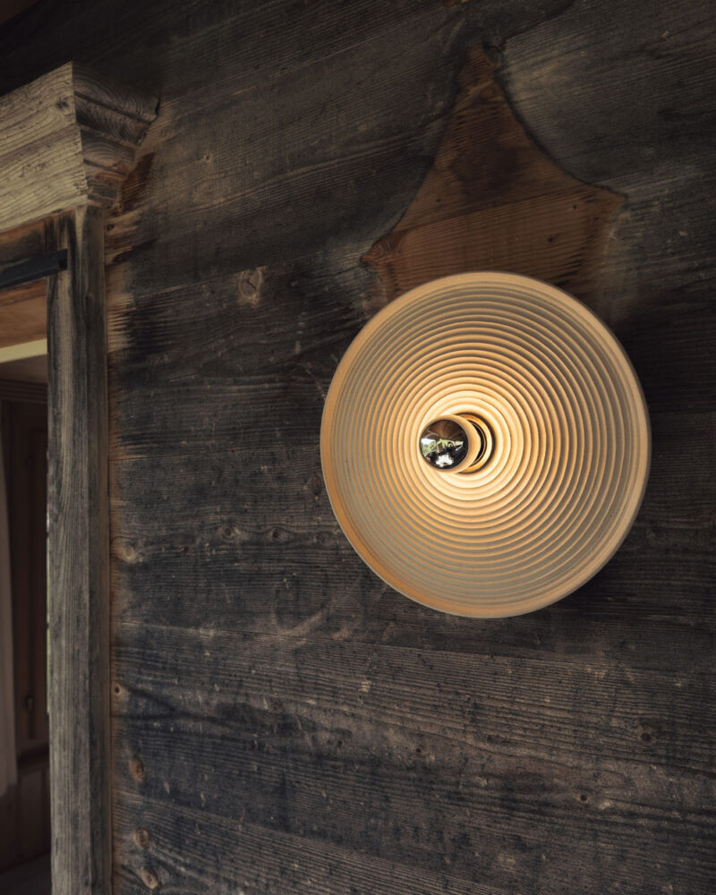 Handgemachte Wandlampe aus steingrauem Ton (Steinzeug) mit stilvoller, dezenter Metall-Fassung in schwarz für die direkte Montage an Wand oder Decke, geeignet für Leuchtmittel E27.